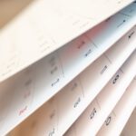 Nahaufnahme von Kalenderblättern die durchgeblättert werden.