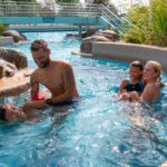Eine Familie spielt mit ihren Söhnen im Ausschwimmkanal vom Celler Badeland