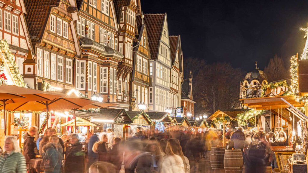Festlich beleuchteter Weihnachtsmarkt Celle inmitten der historischen Fachwerkhäuser der Altstadt. Zahlreiche Besucher schlendern zwischen liebevoll dekorierten Ständen.