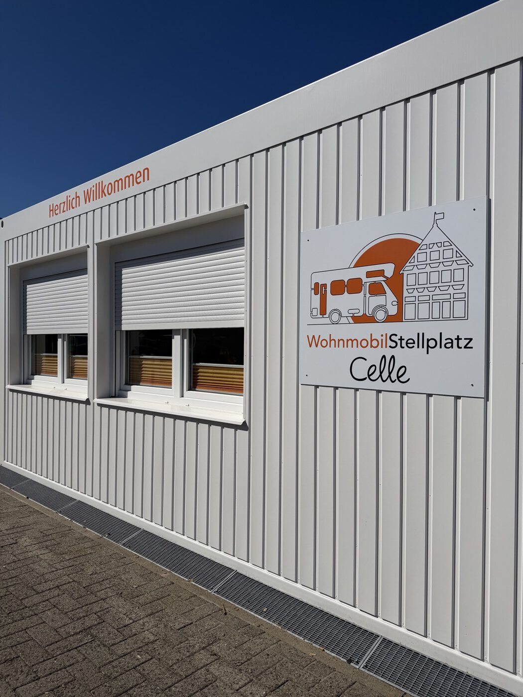 Büro-Container von der Seite mit Logo vom Wohnmobilstellplatz