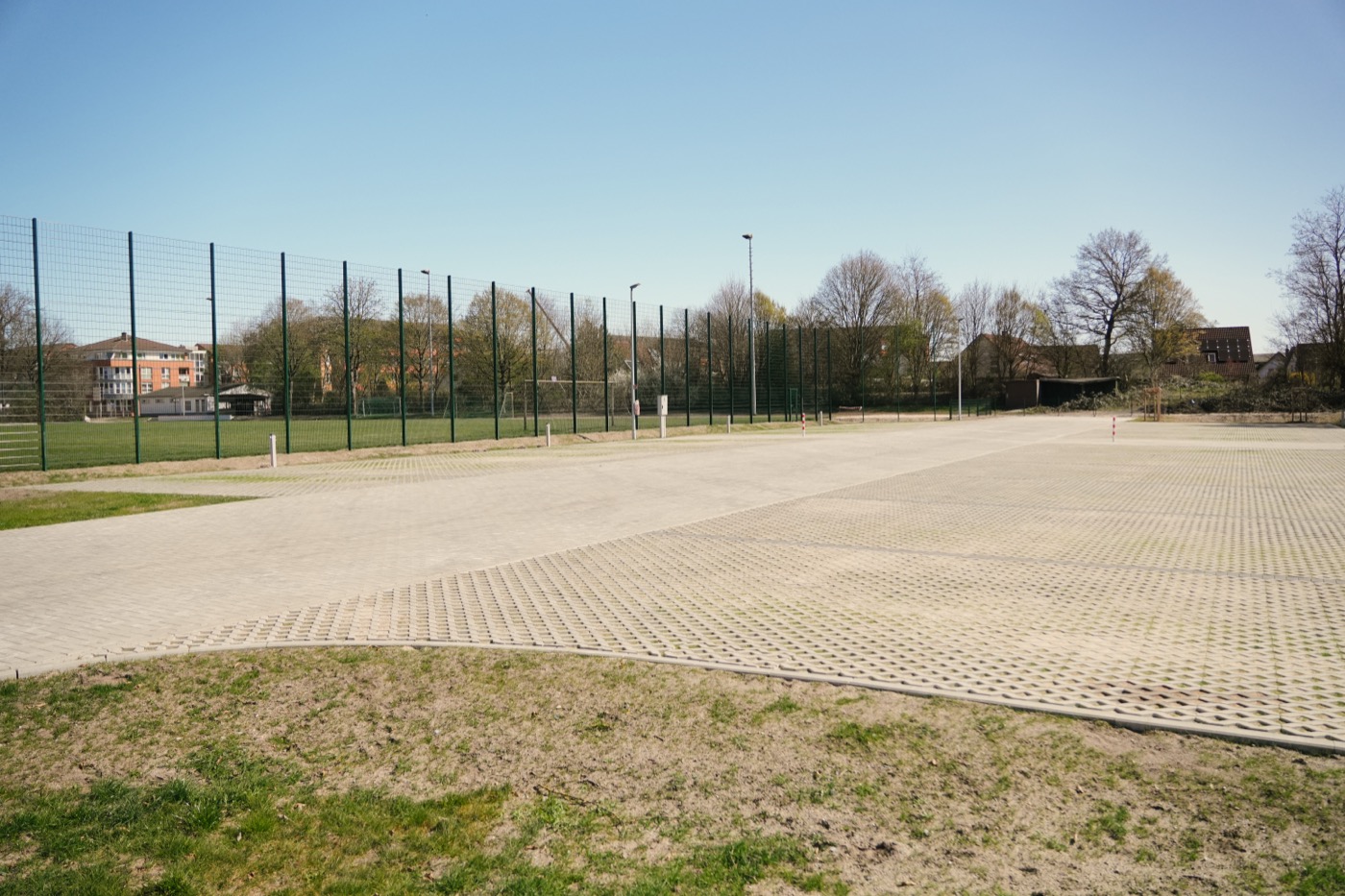 Die leeren Stellplätze auf dem Wohnmobilstellplatz mit Sportplatz im Hintergrund